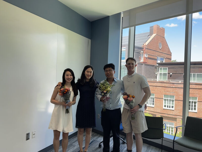 Cameron and three others holding flowers after the defense